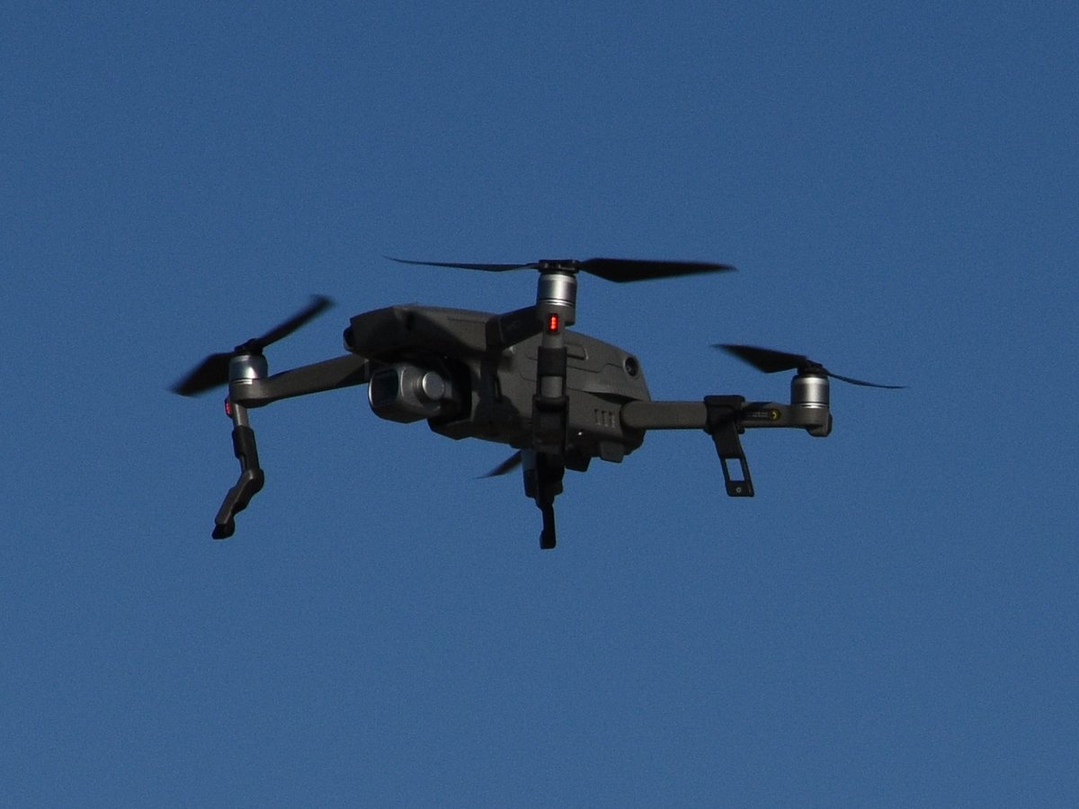 DJI Mavic 2 Pro drone hovering against a clear blue sky